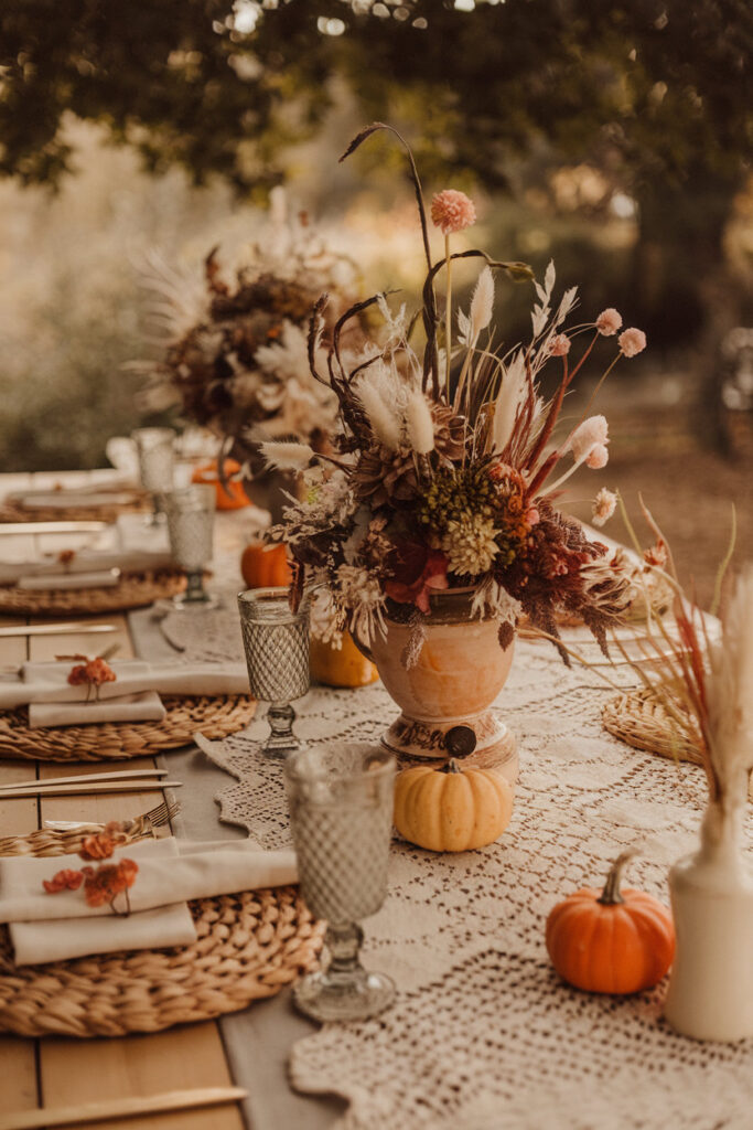 Thanksgiving table setting styled with a rustic runner and vintage dishware.

